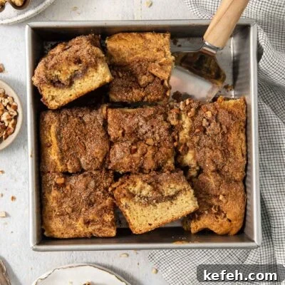 sliced coffee cake in the baking pan with two slices turned to show the inside crumb.