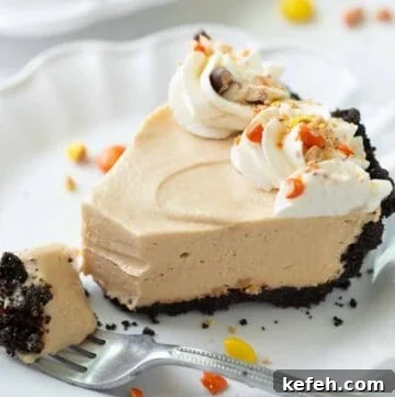 slice of peanut butter pie with gluten free oreo crust on a white plate
