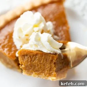Slice of pumpkin pie with a piece on a fork