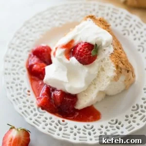 slice of gluten-free angel food cake on white plate with strawberries
