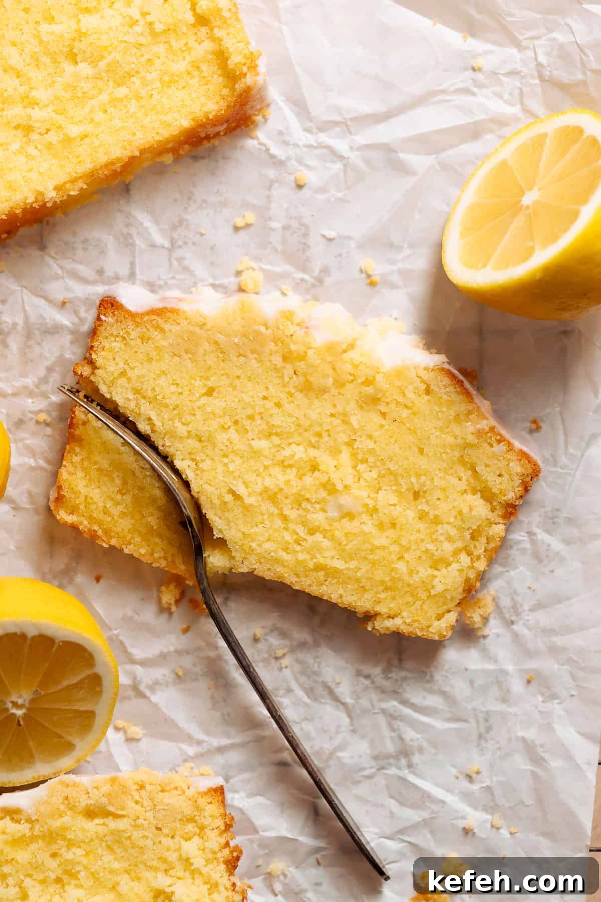 A slice of lemon cake with a fork cutting into it.