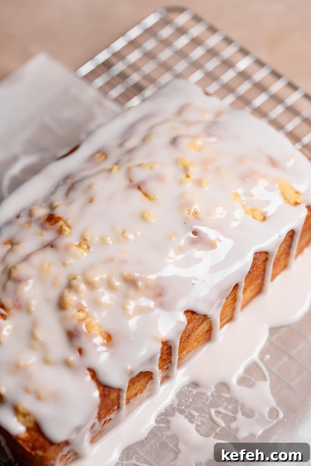 The iced lemon loaf on parchment paper before cutting.