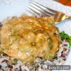 Creole Chicken with Green Chili Cream Sauce Recipe 2 Chicken with chili cream sauce on a bed of rice on a white plate. There is a fork at the top of the plate.