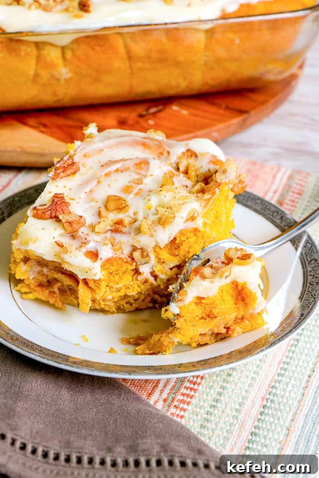 cinnamon roll on a small plate with a fork on the plate