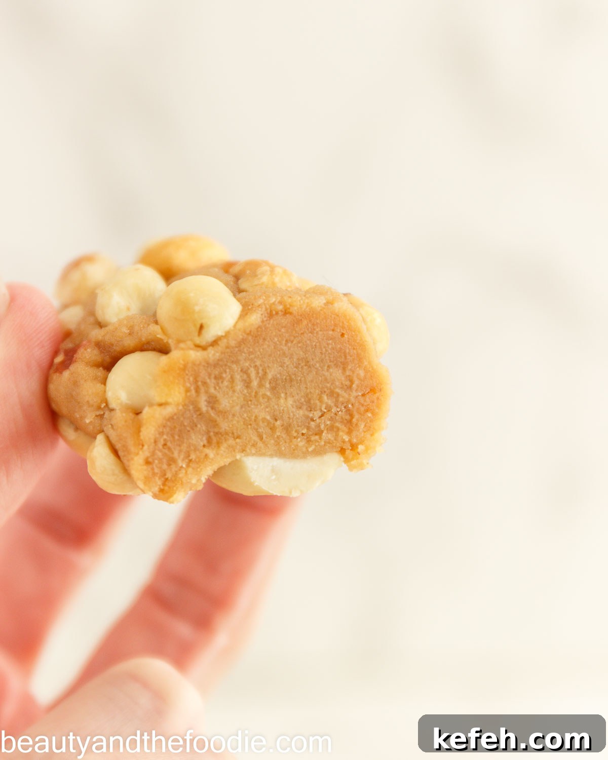 A keto payday bar held in a hand with a bit out of it.