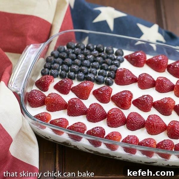 Berry Cheesecake Flag Dessert in a pyrex dish topped with blueberry and strawberry stars and stripes.
