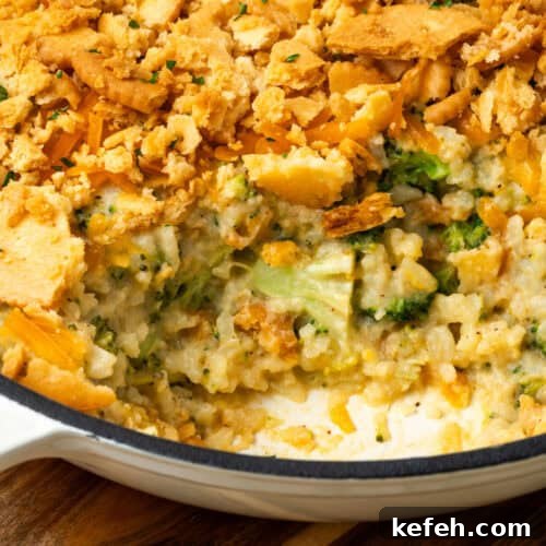 A broccoli rice casserole with a scoop taken out showing the creamy inside.
