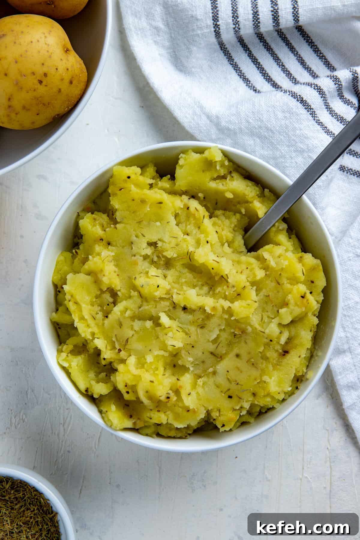 Creamy Dairy-Free Mashed Potatoes: Fluffy, Vegan Recipe 5 Mashed potatoes in white bowl with spoon inserted.