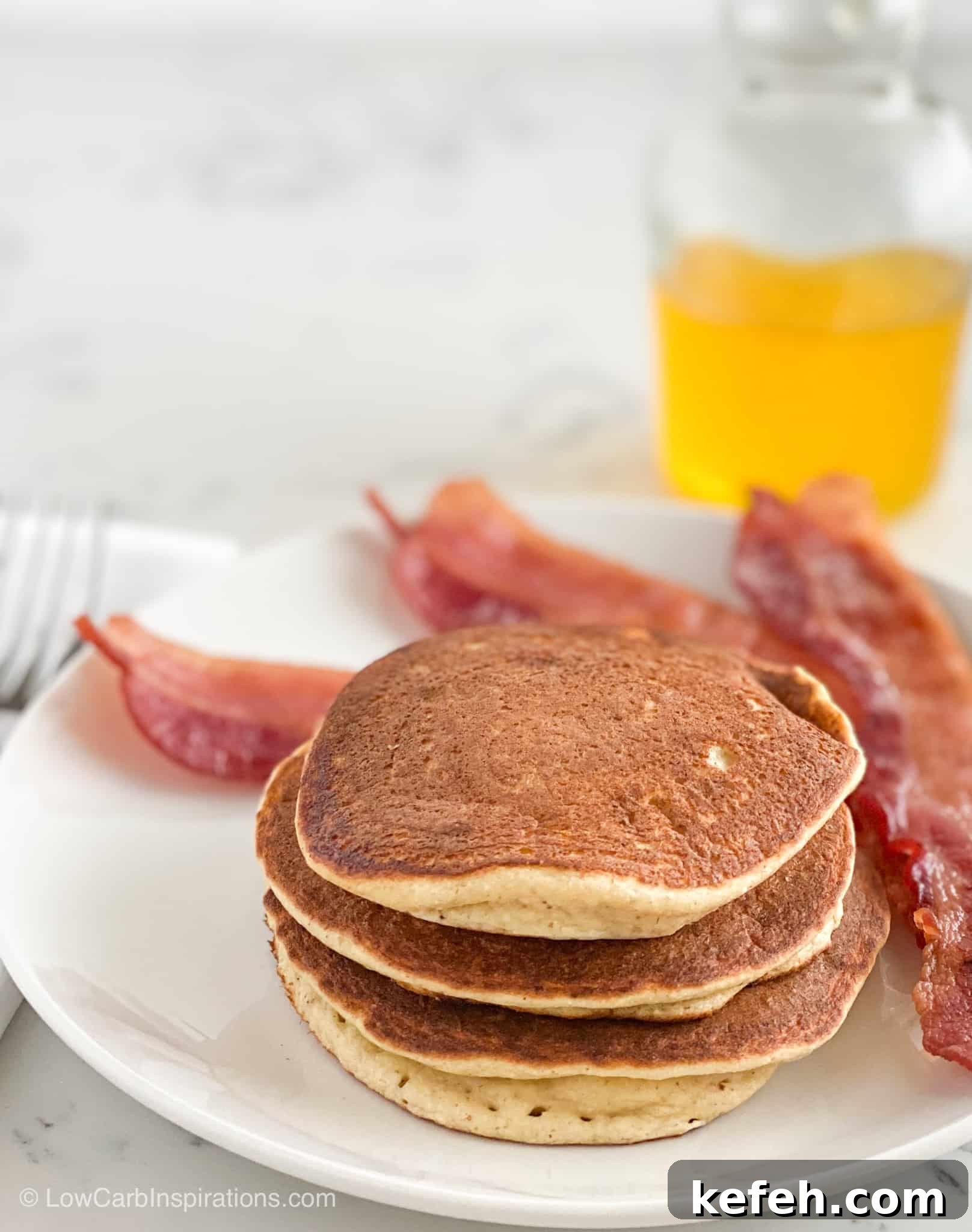 3 Fluffy Keto Pancakes served with bacon and a side of banana syrup that's sugar free