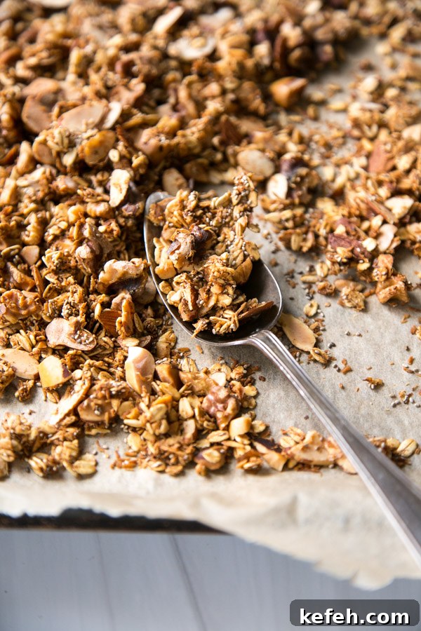 sugar-free granola on a sheet pan with a spoon close up