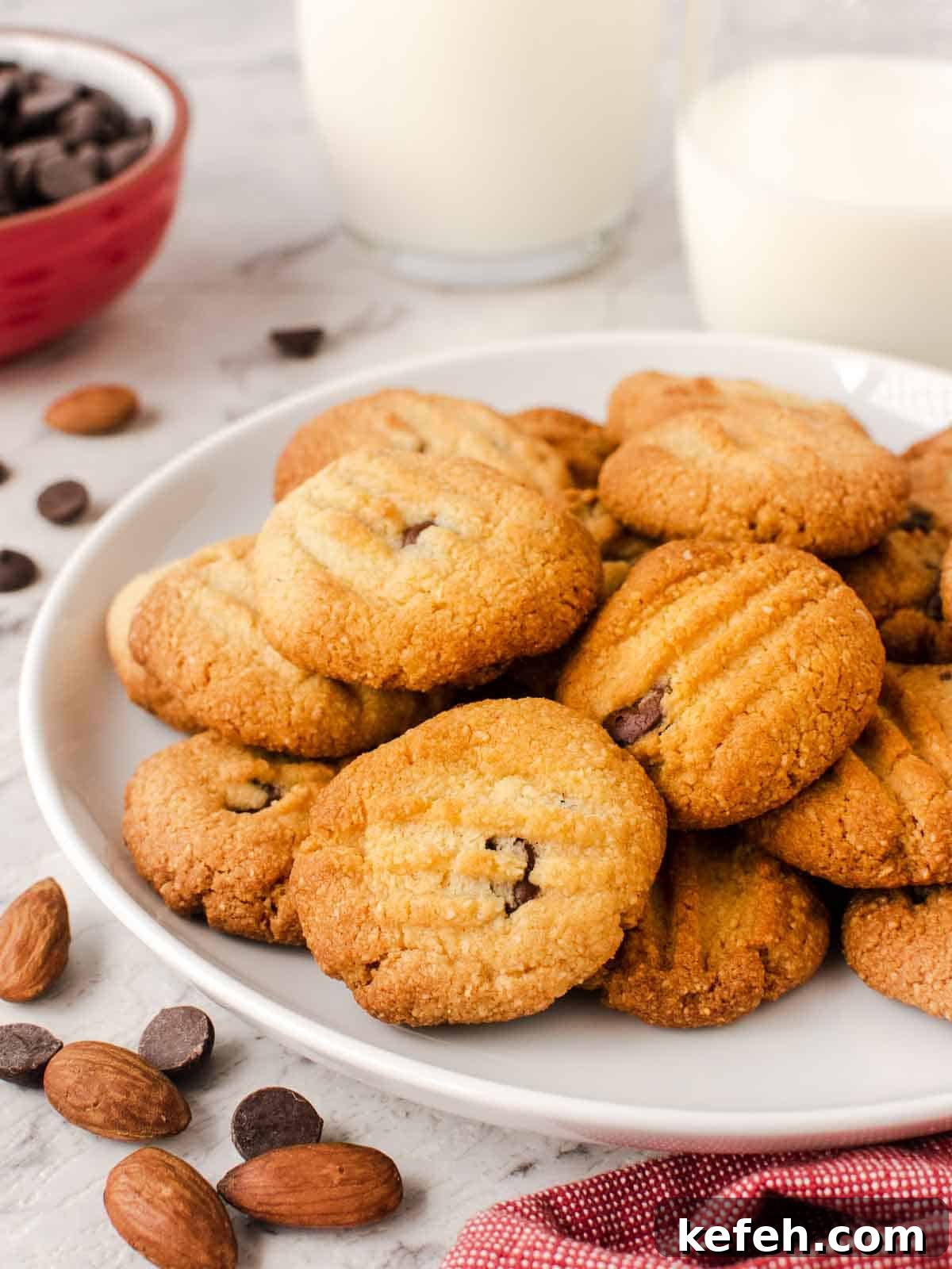 Crispy Almond Flour Cookies: Simple Gluten-Free Treats 2 Almond flour cookies with chocolate chips on a white plate.