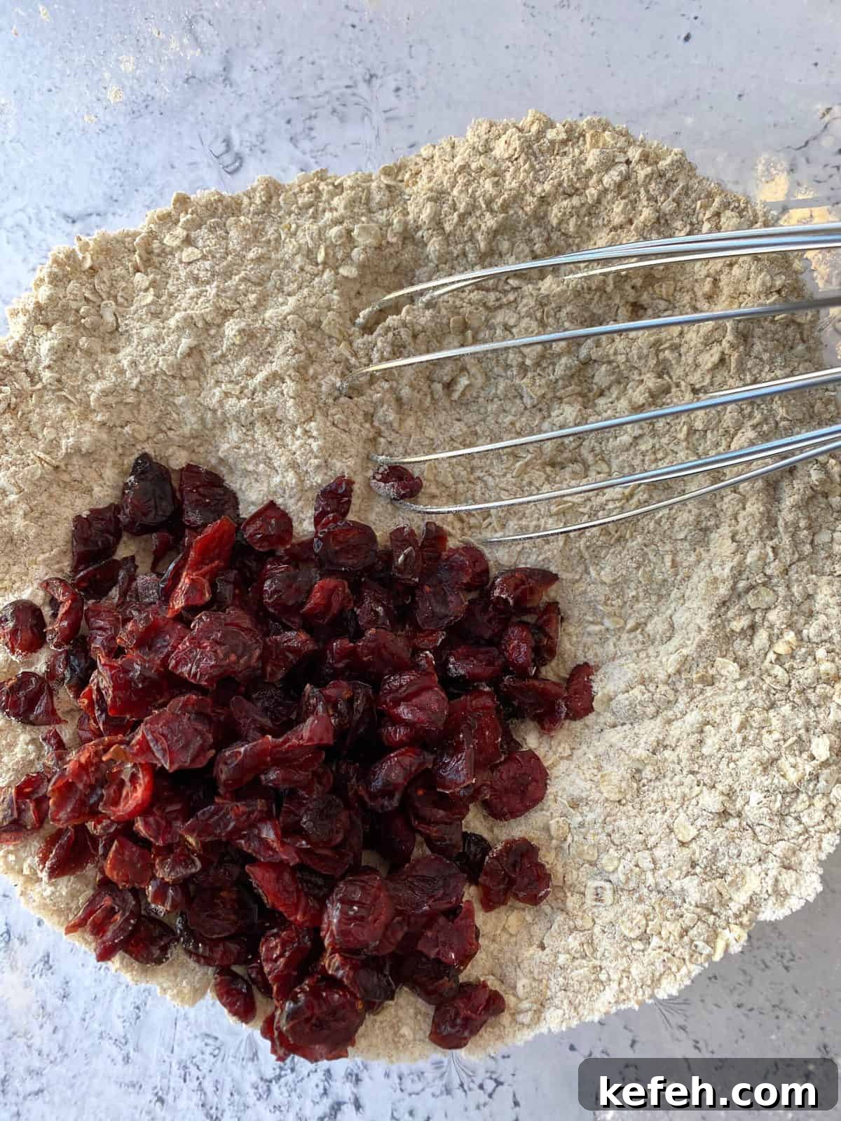 Carrot Banana Muffins with Cinnamon and Honey 7 Dried cranberries and dry ingredients in a bowl with a whisk.