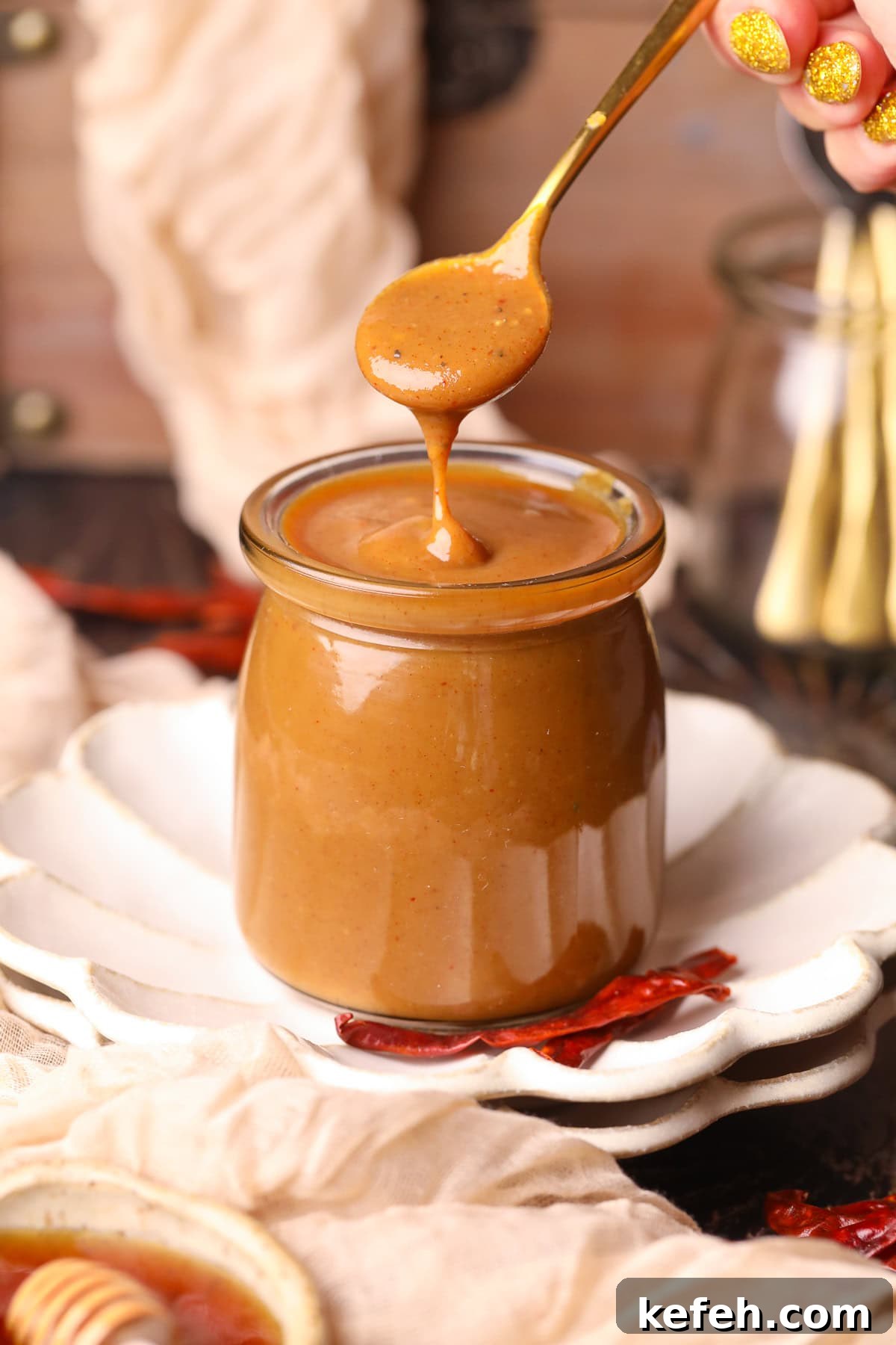 Memphis Honey Gold BBQ Sauce Recipe 2 memphis honey gold sauce in a glass jar with a gold spoon.