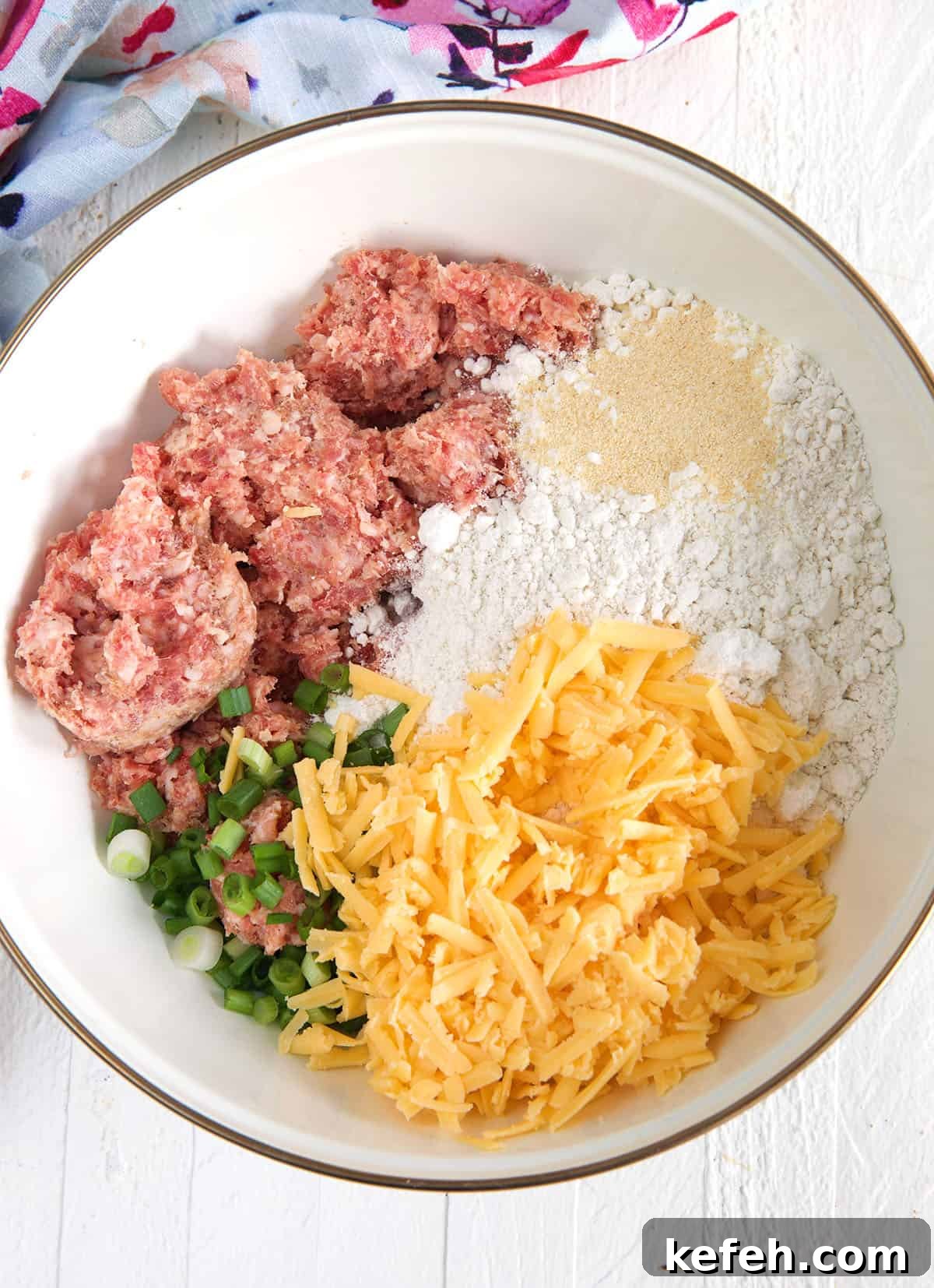 Irresistible Sausage Ball Recipe for Parties and Game Day 3 The ingredients for sausage balls are placed in a white mixing bowl.