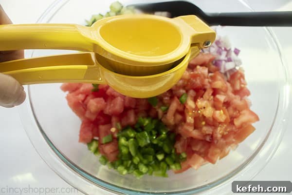 Fresh lime squeezed on top of salsa ingredients
