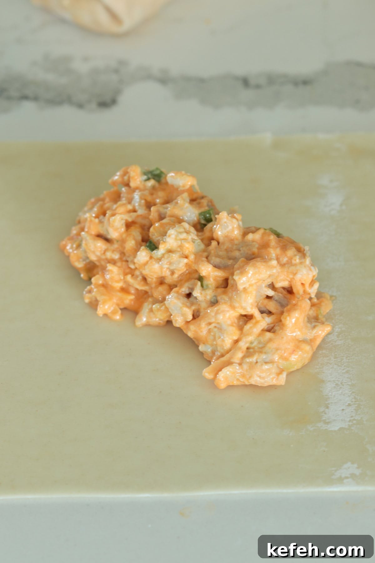 Buffalo chicken filling on egg roll wrapper.