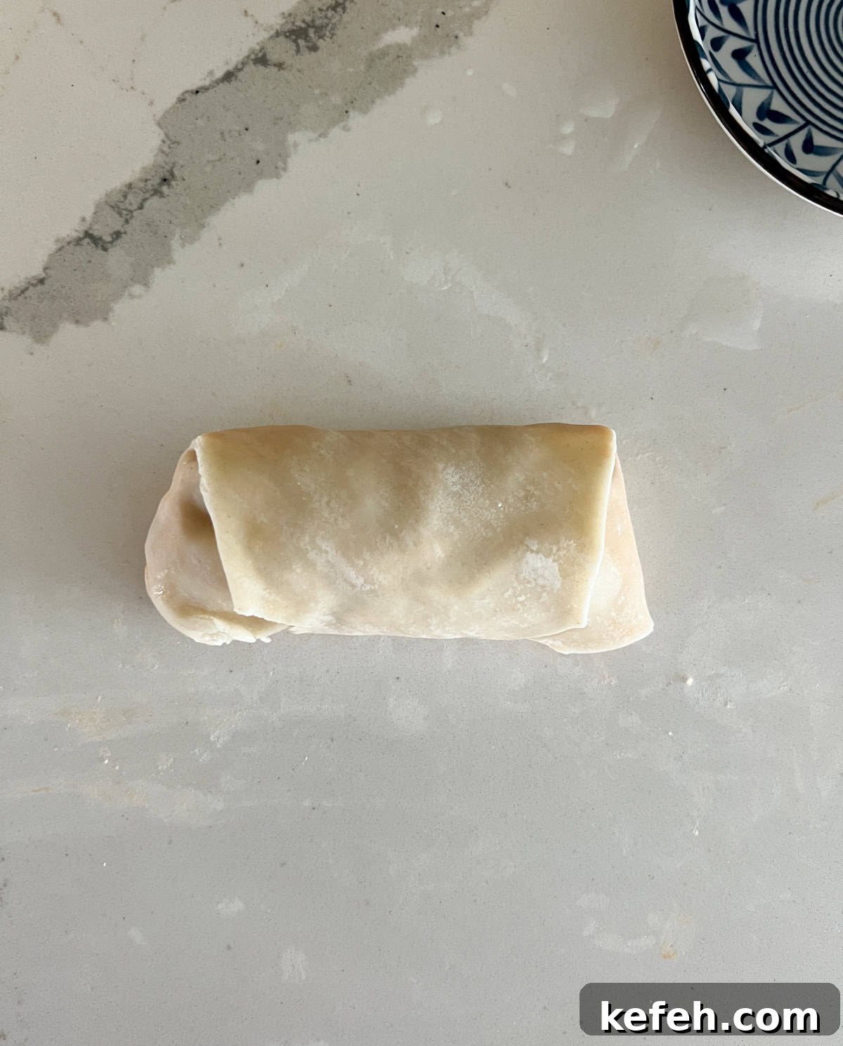 Rolled buffalo chicken egg roll ready for frying.