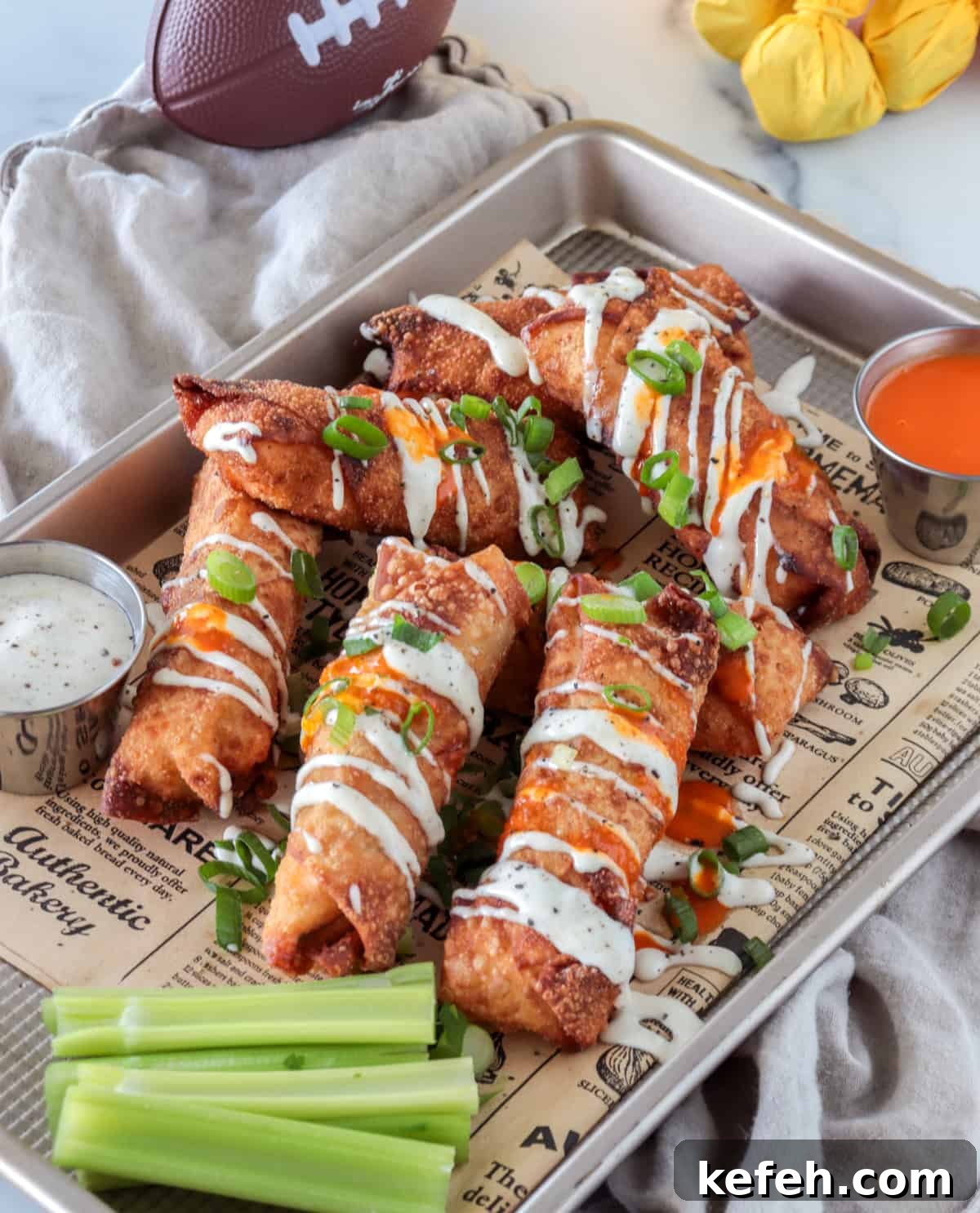 Buffalo chicken egg rolls with a drizzle of ranch dressing.
