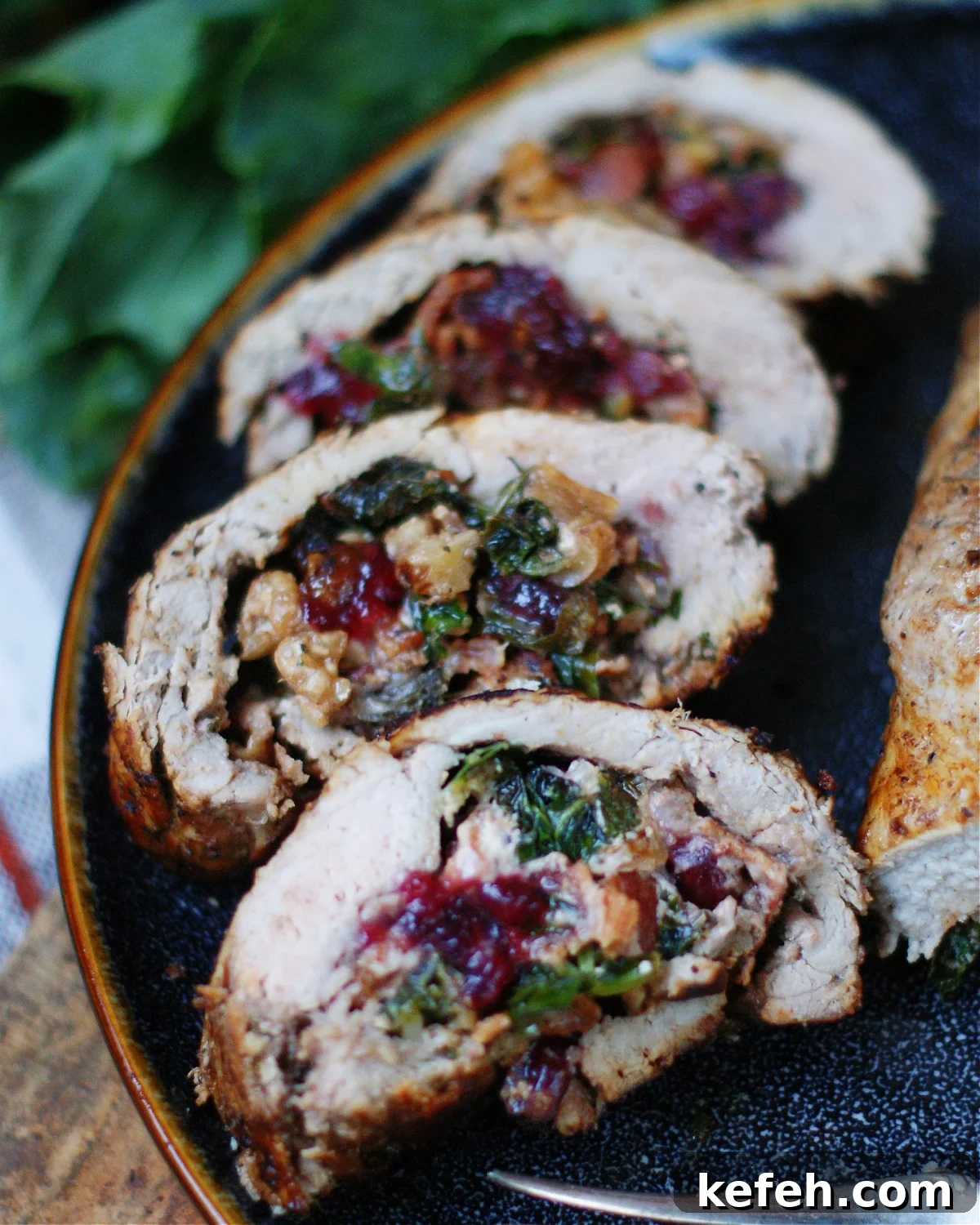 Sliced stuffed pork tenderloin on a holiday platter