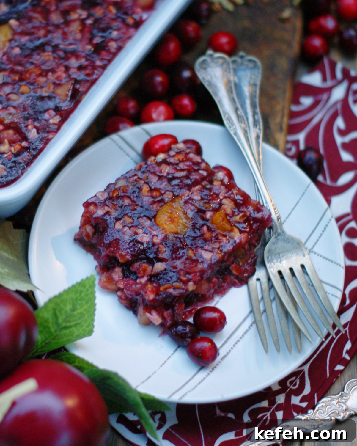 An overhead view of a slice of cranberry jello salad to show the texture and suspended fruit in the jello.