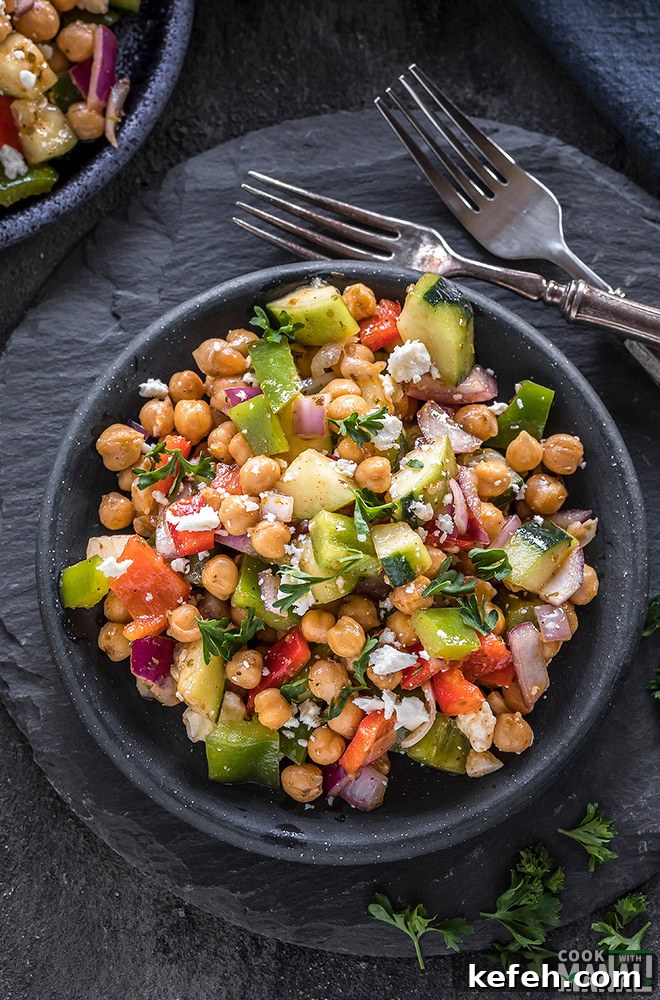 Mediterranean Chickpea Salad with Feta, Cucumber & Lemon Dressing 3 mediterranean chickpea salad in a small black plate with forks on the side
