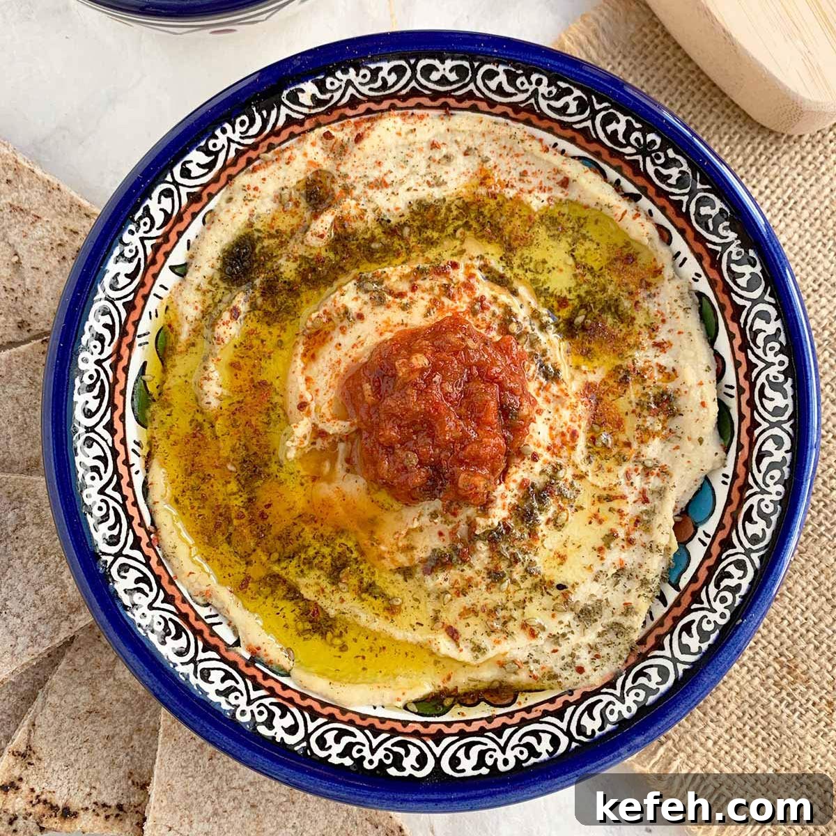 Last-Minute Rosh Hashanah Prep: Quick Guide to Ready Your Home and Table 15 Top down view of preserved lemon hummus in blue bowl.