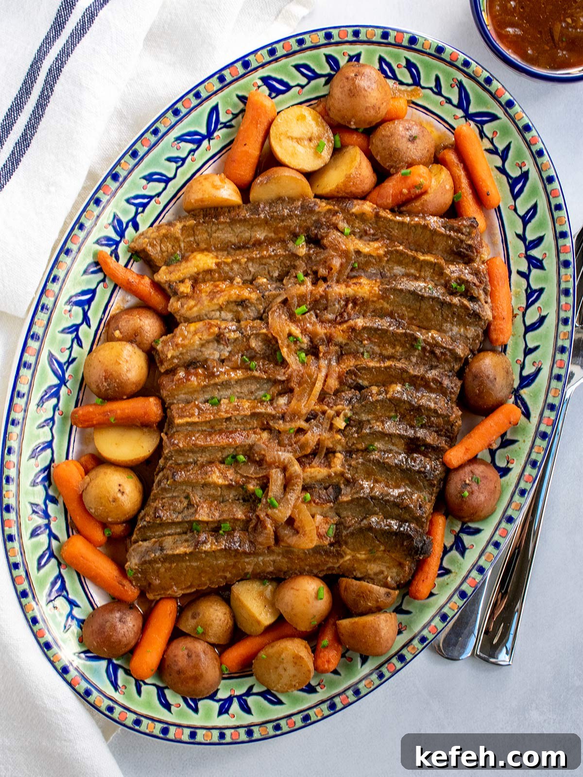 Last-Minute Rosh Hashanah Prep: Quick Guide to Ready Your Home and Table 3 A platter of brisket with potatoes and carrots surrounding the meat and some gravy in a small bowl on the side.