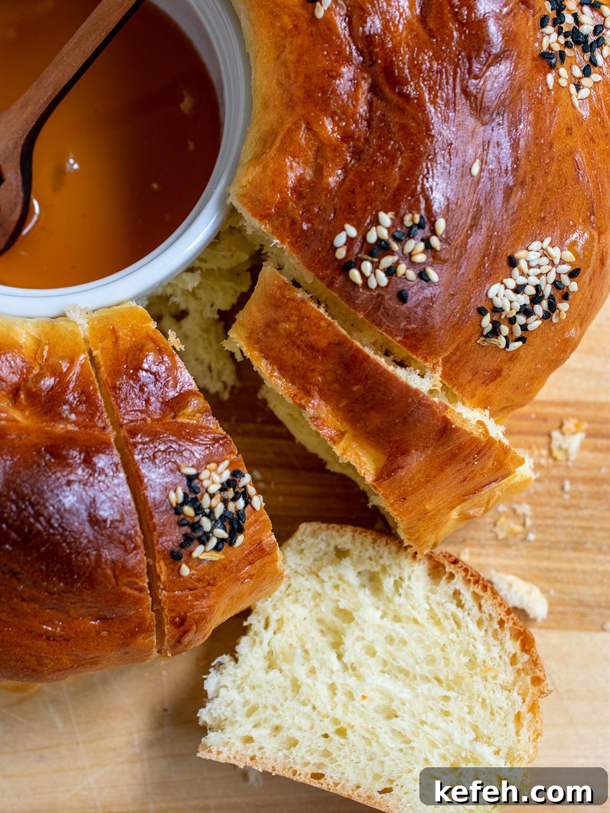 Last-Minute Rosh Hashanah Prep: Quick Guide to Ready Your Home and Table 24 Close up of round challah with a slice face up and part of the honey ramekin showing.