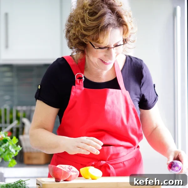 Last-Minute Rosh Hashanah Prep: Quick Guide to Ready Your Home and Table 45 Beth Lee in red apron looking at vegetables on cutting board