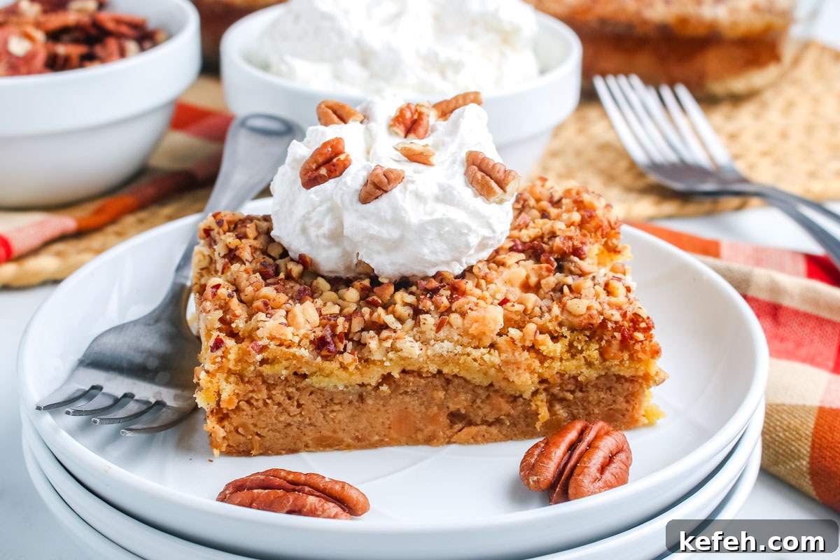 Close-up of sweet potato dump cake slice with whipped cream and pecans.