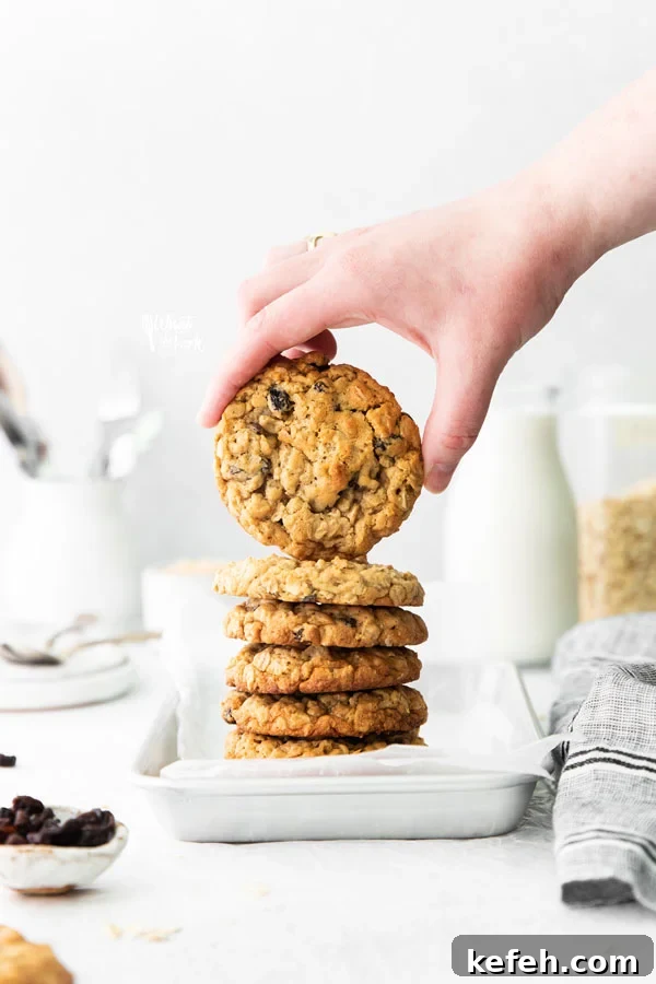 a hand holding a gluten free oatmeal raisin cookie showing the top