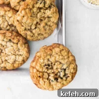 overhead shot of baked gluten free oatmeal raisin cookies on a silver metal sheet pan