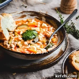 Classic French Pistou Soup Recipe: Provençal Vegetable Stew with Basil 19 Soupe au Pistou served in a brown and gray ceramic bowl and photographed at an angle.