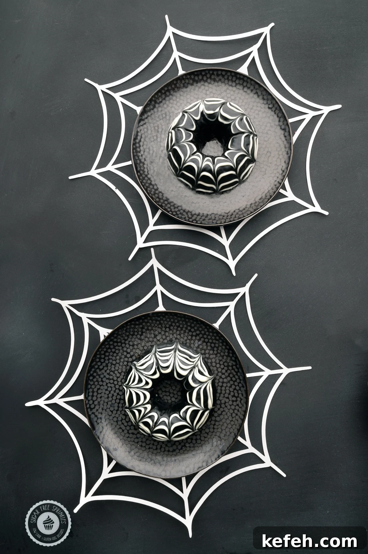 Chocolate glazed keto donuts with a spider web design on dark black plates with white paper spider webs 
