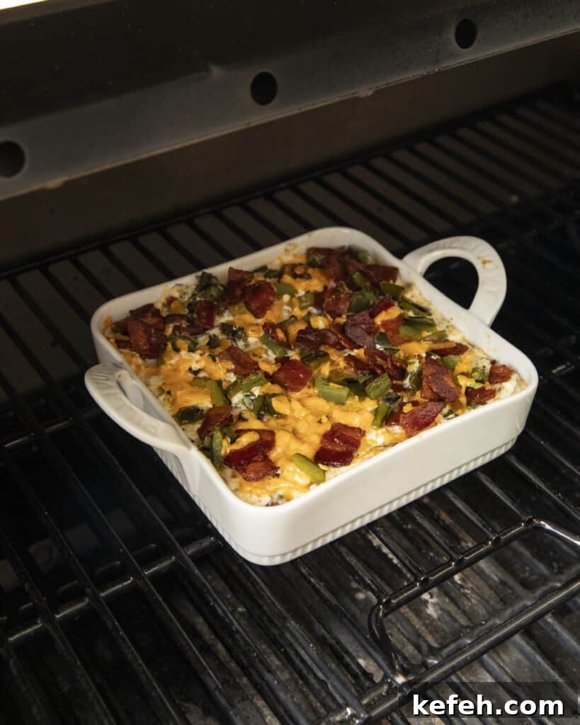 Finished dip topped with bacon and jalapeños