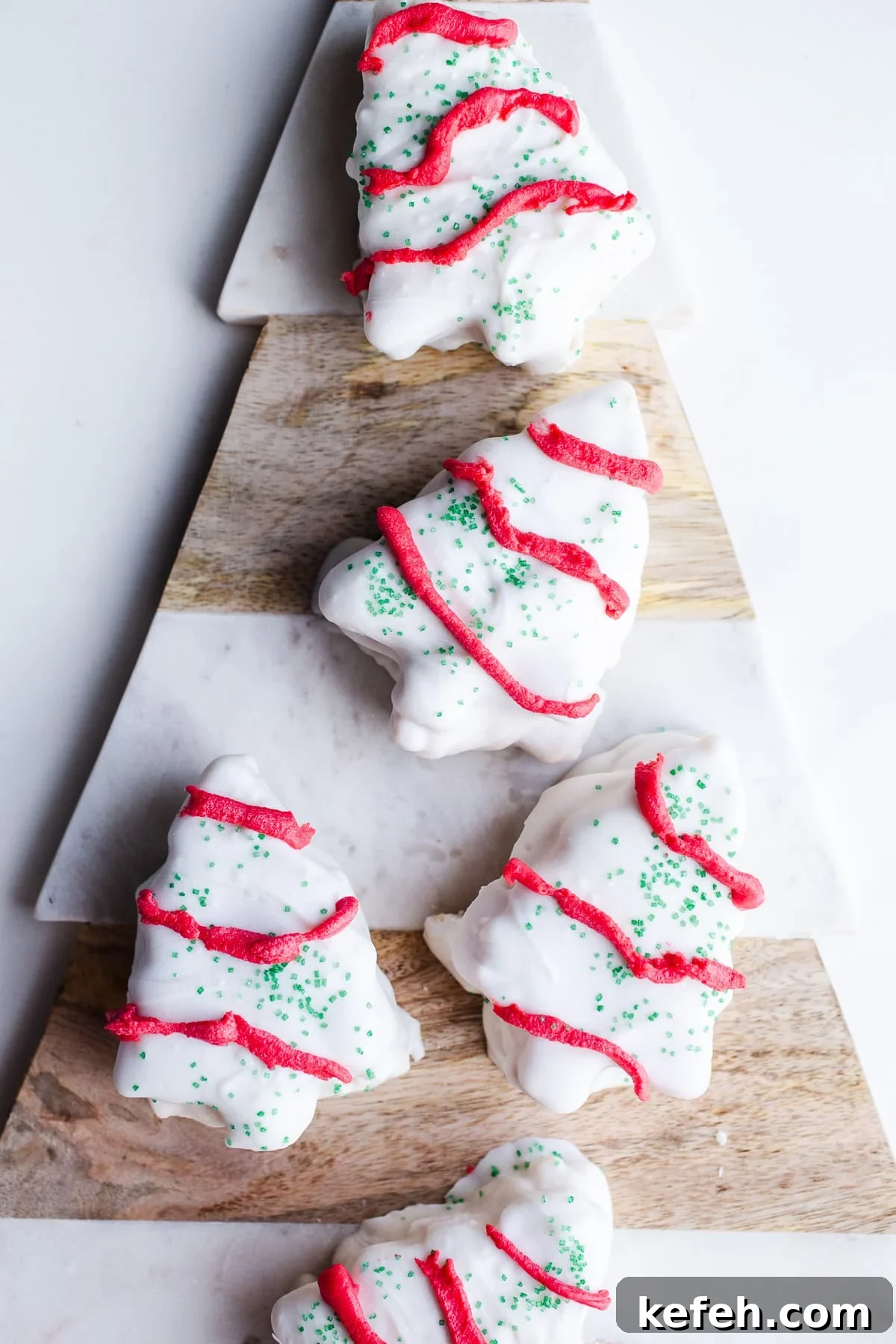 Little Debbie Christmas Tree Cakes Copycat Recipe for Holidays 2 White chocolate Christmas tree cakes on a marbled platter.