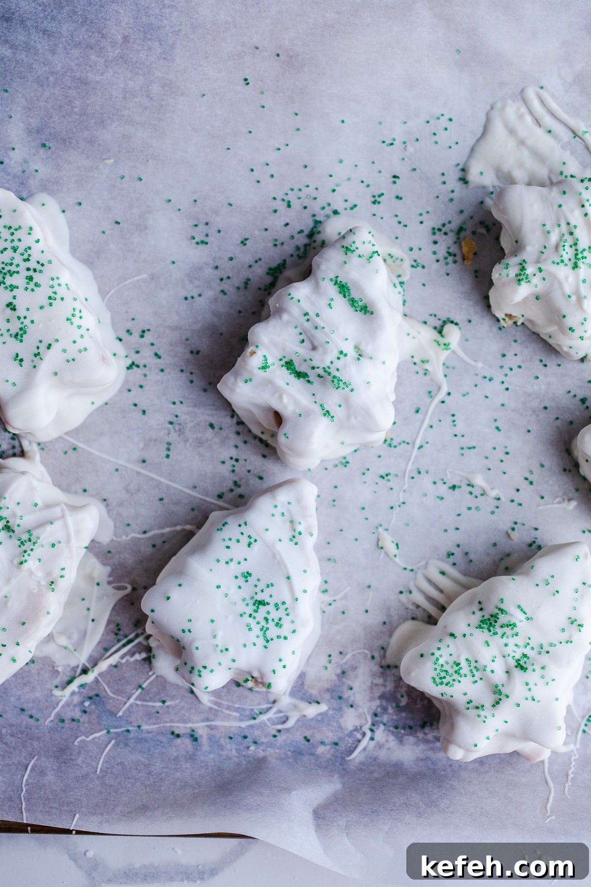 Little Debbie Christmas Tree Cakes Copycat Recipe for Holidays 12 Christmas tree cakes dipped in white chocolate with green sprinkles.