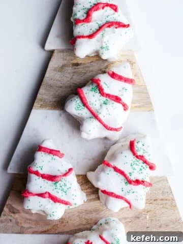 White chocolate Christmas tree cakes on a marbled platter.