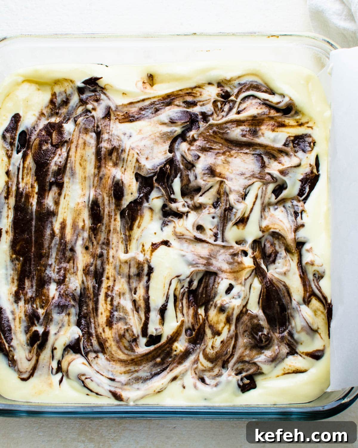 Decadent Cheesecake Brownie Squares: Fudgy Layers with Cream Cheese Swirl 8 Swirling the remaining brownie batter into the cheesecake layer.