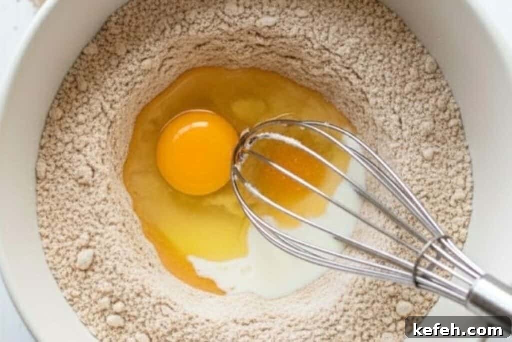 Make a well in the centre and add the egg, melted butter, milk, and orange juice.