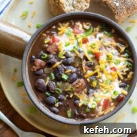 Instant Pot Black Bean Soup Recipe — Quick, Flavorful Meal 12 Closeup of the top of the soup bowl, with garnishes and a roll alongside.