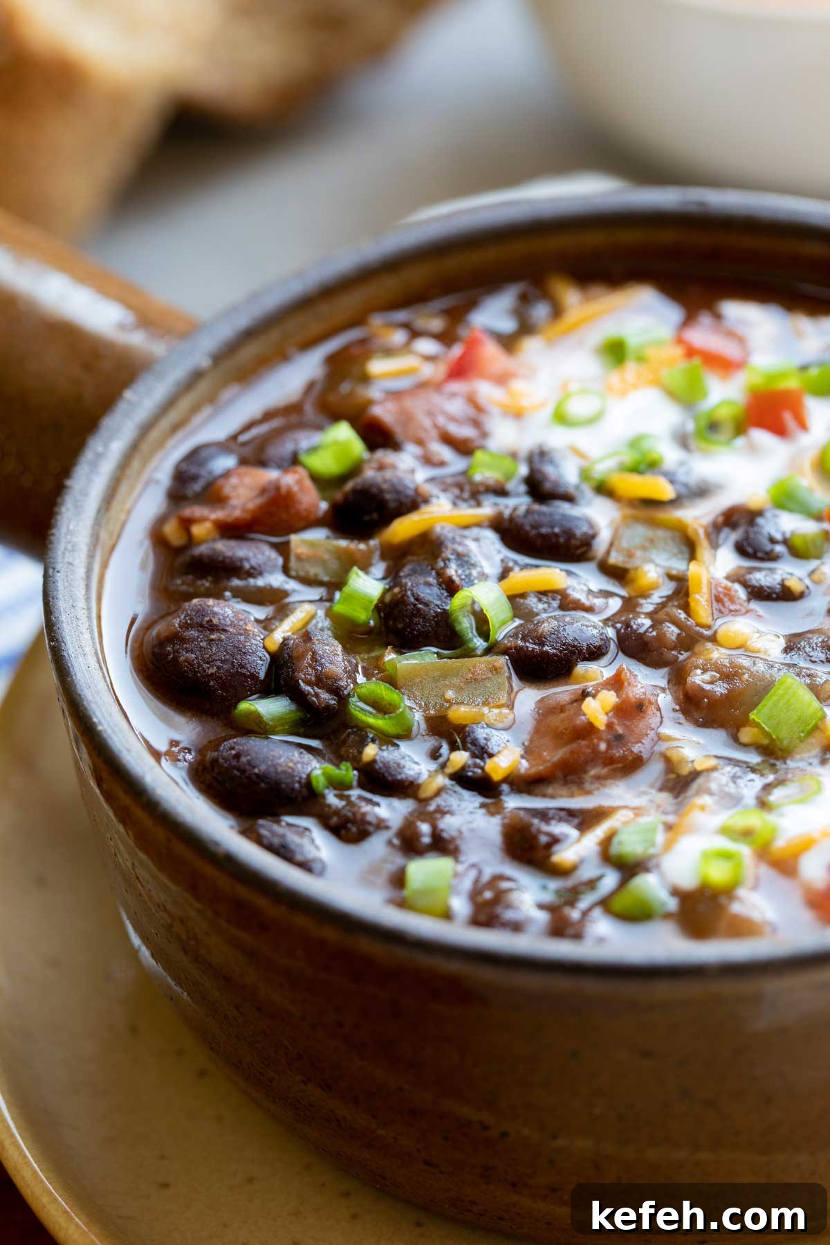 Instant Pot Black Bean Soup Recipe — Quick, Flavorful Meal 3 Closeup of soup served in crockery bowl, so you can really see the texture of the black beans and sausage.