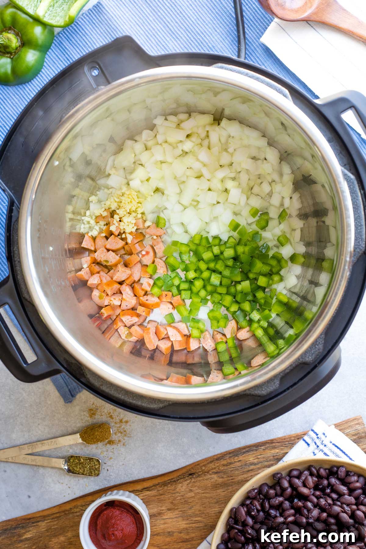 Instant Pot Black Bean Soup Recipe — Quick, Flavorful Meal 5 First recipe ingredients sauteeing in Instant Pot with spices and black beans waiting alongside.