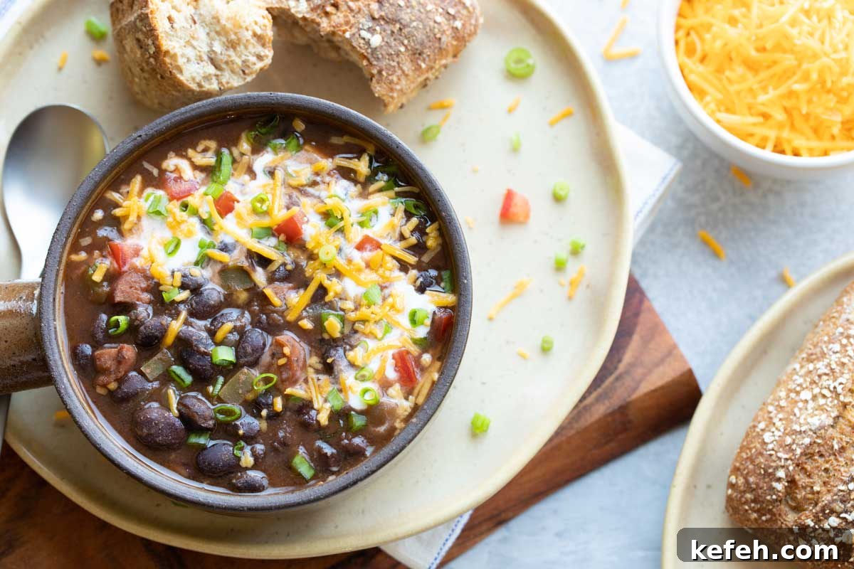 Instant Pot Black Bean Soup Recipe — Quick, Flavorful Meal 9 Soup served alongside whole grain rolls with extra cheese nearby.