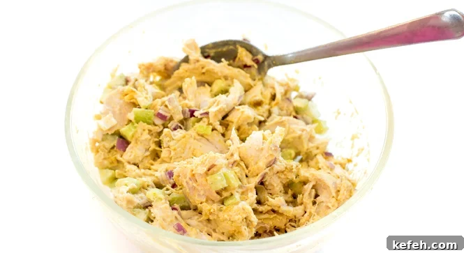 Curried Chicken Salad with Grapes & Toasted Almonds 6 Mixing all of the ingredients together in a mixing bowl with a spoon.