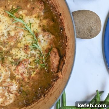 French Onion Chicken Casserole with Melted Gruyère 10 french onion chicken bake in a cast iron pan, with green beans and potatoes next to it.