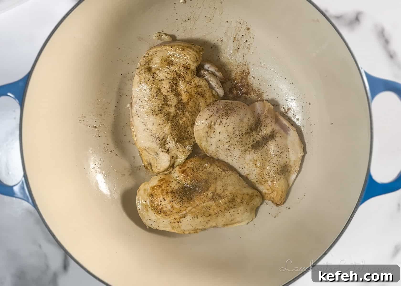 French Onion Chicken Casserole with Melted Gruyère 4 browning chicken in a cast iron pan.