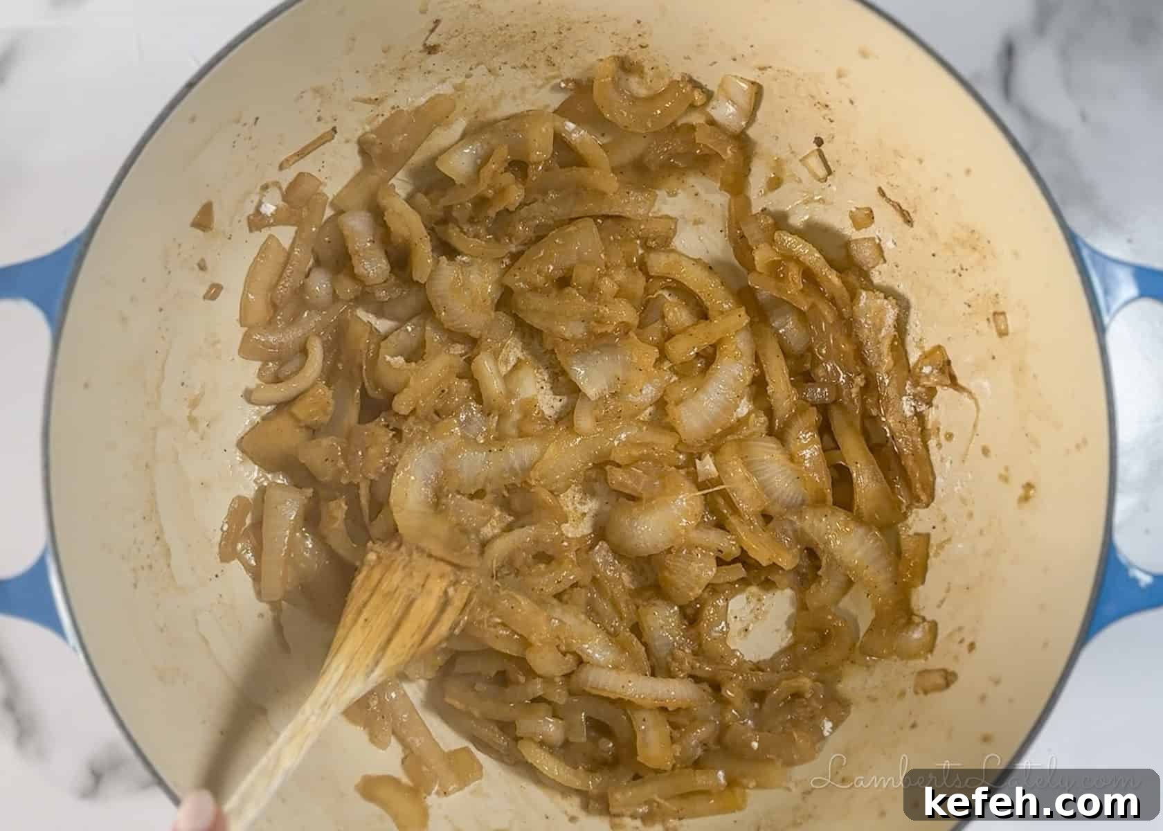 French Onion Chicken Casserole with Melted Gruyère 5 caramelizing onions in a cast iron pan.