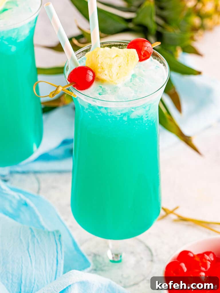 Blue Hawaiian drink in hurricane glass with pineapple garnish
