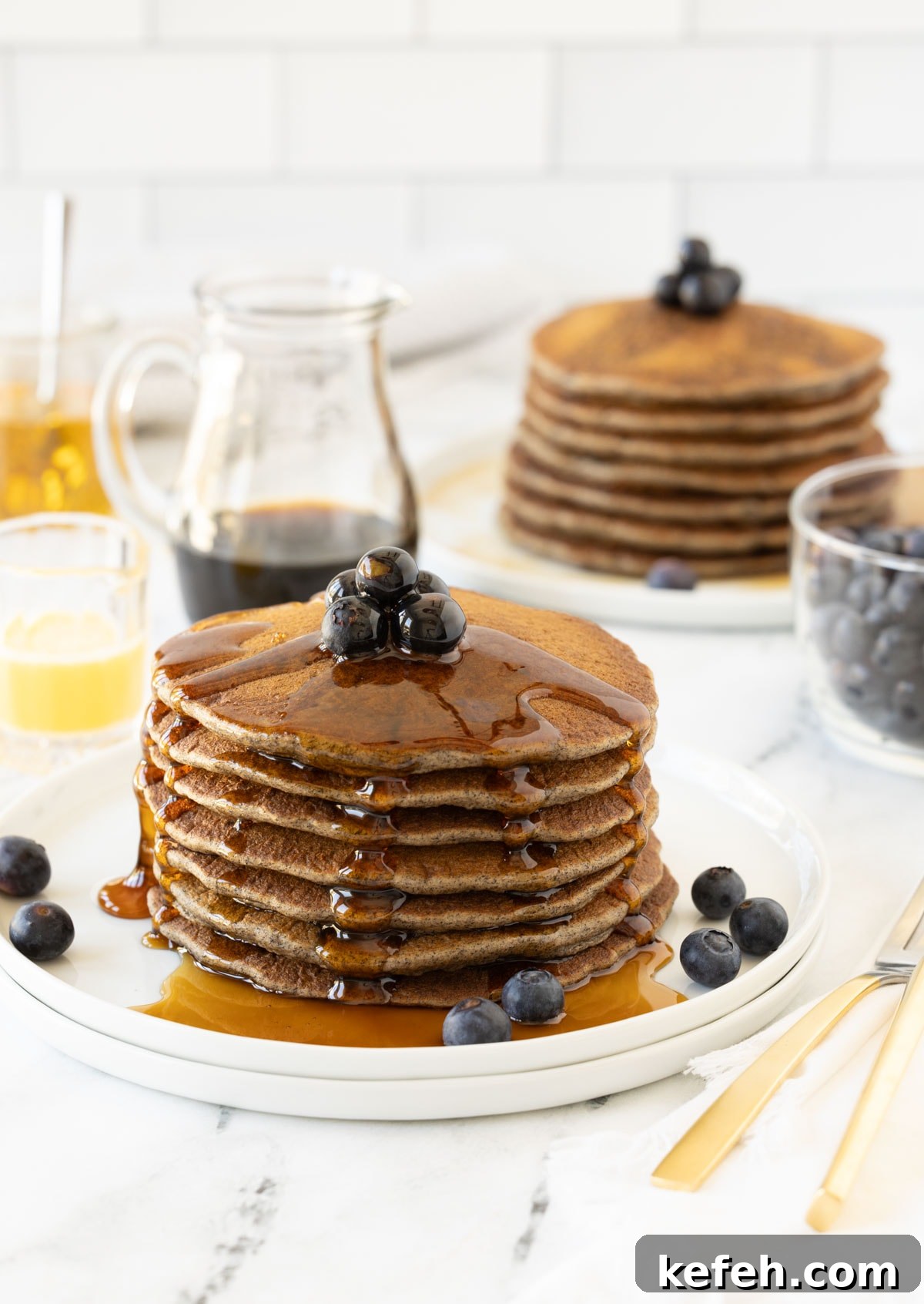 A big stack or buttermilk buckwheat pancakes dripping with maple syrup.